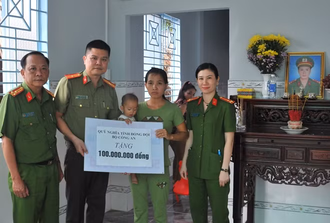 Thiếu tá Nguyễn Văn Bình trao tặng số tiền 100 triệu đồng cho vợ con liệt sĩ, Đại úy Phạm Phi Long (công tác tại Phòng Cảnh sát PCCC quận Bình Tân cũ).