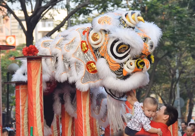 Một em bé sợ không dám nhìn mặt chú lân