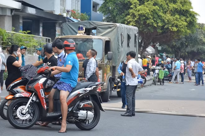 Nhiều cư dân của chung cư không thể lên căn hộ của mình nên phải ngồi tập trung tại khu vực đường nội bộ
