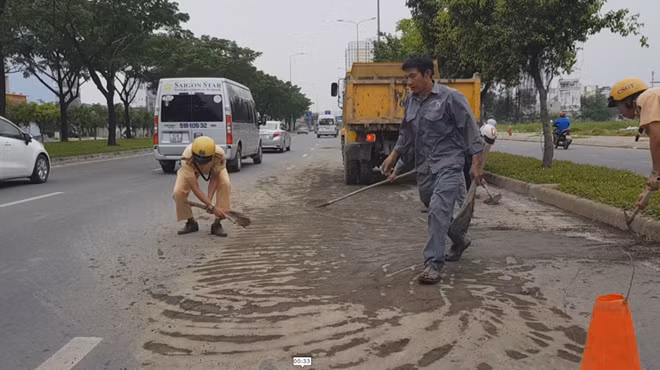 Tổ CSGT phối hợp với công nhân vệ sinh dọn dẹp bùn đất vương vãi trên đại lộ Võ Văn Kiệt