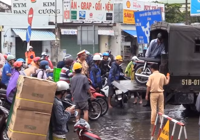 Nhiều người dừng xe để được xe chuyên dụng chở qua điểm ngập