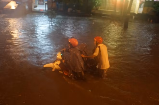 Người dân khốn đốn qua khỏi các tuyến đường ngập