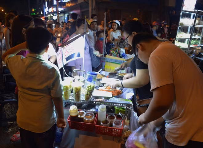 Các món ăn vặt được những du khách đi thăm quan đường hoa Nguyễn Huệ yêu thích nên nhiều người bán hàng rong đã tụ tập về khu vực này.