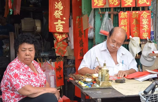 Một ông đồ viết chữ tại khu bán đồ trang trí. Nhiều người Hoa dịp Tết đến thường đến đây xin chữ dán khắp nhà đón Tết