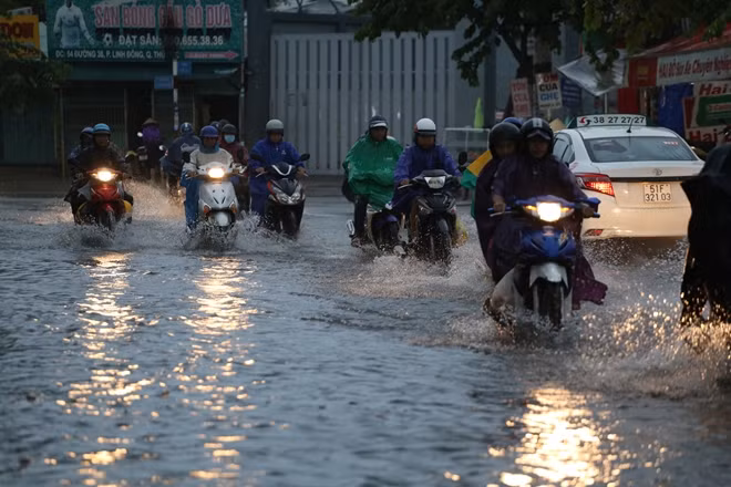 Người dân lưu thông trong cơn mưa gặp nhiều khó khăn