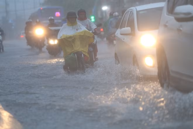 Mưa trắng trời khiến nhiều phương tiện phải bật đèn khi lưu thông trên đường