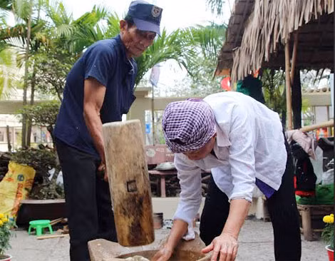 Hai nghệ nhân đang thao tác cách làm bánh phồng.