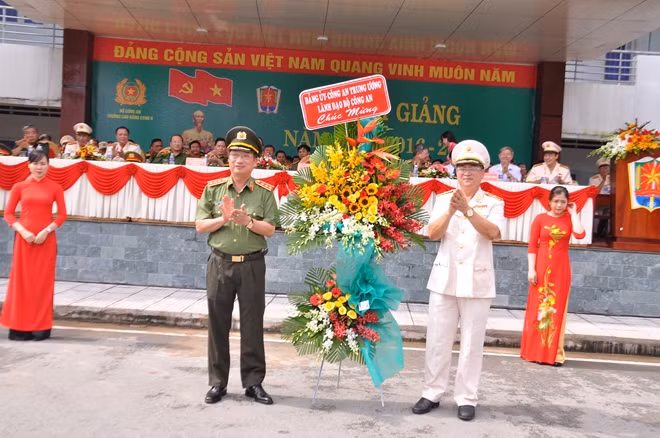 Hiệu trưởng Vũ Đức Khiển đón nhận lẵng hoa tươi thắm từ đồng chí Thứ trưởng trao tặng thầy trò nhà trường.
