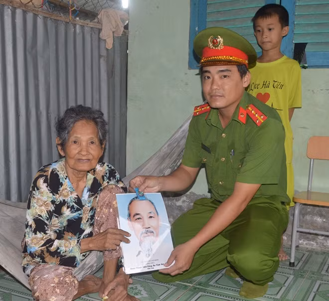 Đoàn công tác tặng ảnh Bác Hồ cho bà con trong xã.