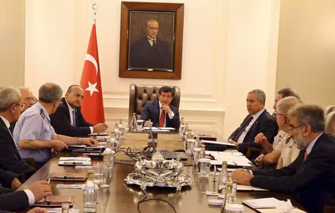 Thủ tướng Thổ Nhĩ Kỳ Ahmet Davutoglu (ngồi giữa) trong một cuộc họp an ninh tại Ankara ngày 25/7. Ảnh: Reuters.