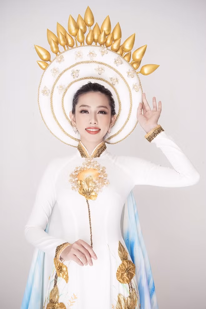 "Bộ trang phục với đầu đội khăn vấn kết hợp với trâm cài lược dắt như hình ảnh Hoàng hậu ngày tấn phong ngôi vị, tất cả được truyền tải lên bộ Quốc Phục lần này, với hy vọng Thuỳ Tiên sẽ mang sắc vóc Việt Nam đến gần hơn với bạn bè thế giới", NTK tiết lộ.