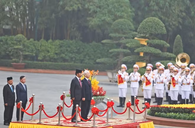 Tổng Bí thư, Chủ tịch nước Nguyễn Phú Trọng và Quốc vương Brunei Darussalam Sultan Haji Hassanal Bolkiah trên bục danh dự, thực hiện nghi lễ chào cờ.