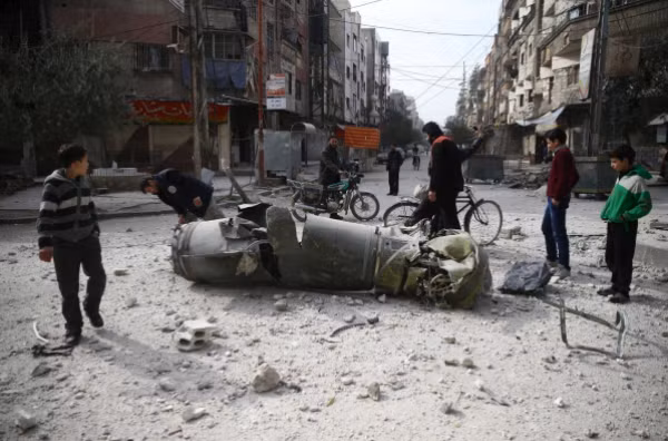 Người dân đang quan sát xác tên lửa tìm thấy ở ở thị trấn Douma, Đông Ghouta. Ảnh: Reuters
