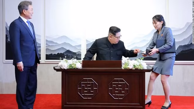 Bà Kim Yo-jong bên cạnh anh trai, nhà lãnh đạo Kim Jong-un, khi ông chuẩn bị viết vào sổ lưu niệm tại Nhà Hòa bình, trước sự chứng kiến của Tổng thống Hàn Quốc Moon Jae-in. Ảnh: CNN