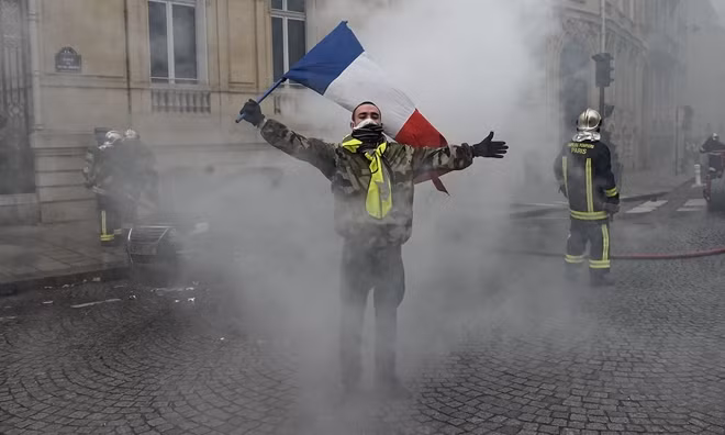 Một người biểu tình xuất hiện trên đường phố Paris. Cũng theo The Guardian, các sĩ quan cảnh sát mặc thường phục đã xác định chính xác vị trí của các phần tử cực đoan và thực hiện hàng trăm vụ bắt giữ trước nguy cơ bạo loạn tiếp tục xảy ra. Ảnh: Getty