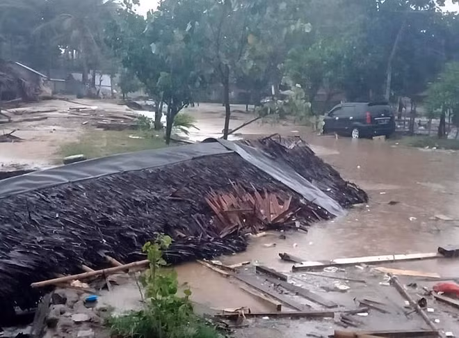 Một ngôi nhà bị cuốn trôi chỉ còn trơ lại nóc nhà nằm giữa dòng nước tại Pandeglang. Ảnh: EPA