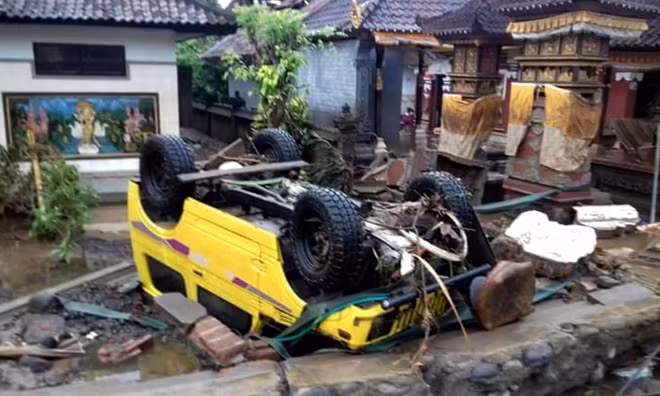 Một chiếc ô tô bị lật ngược sau khi nước biển đổ ập và tràn sâu vào bờ. Sóng thần được hình thành và ập vào bờ vào khoảng 9h30 tối ngày 22-12, khoảng 30 phút sau khi núi lửa Anak Krakatoa nằm ngoài khơi eo biển Sunda phun trào. Ảnh: Reuters