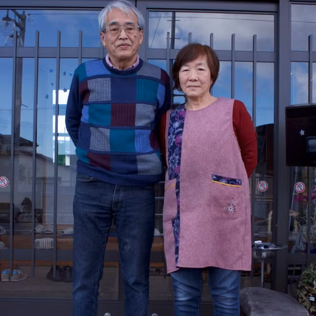 Vợ chồng ông bà Tomoko và Takenori Kobayashi trước dãy nhà trọ của mình.