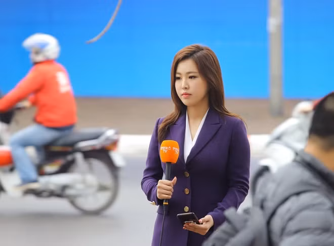 Nữ phóng viên xinh đẹp của đài truyền hình Hàn Quốc tác nghiệp trên đường phố Hà Nội.