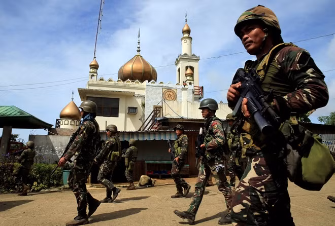 Lực lượng quân đội chính phủ hành quân vào thành phố. Theo hãng thông tấn Reuters, các thành viên lực lượng đặc nhiệm của Philippines đã có những cuộc đấu súng dữ dội với phiến quân Hồi giáo Maute tại thành phố Marawi. Trong khi đó, trực thăng quân đội quần thảo trên bầu trời thành phố, nhả đạn vào các vị trí của phiến quân Maute. Ảnh: Reuters