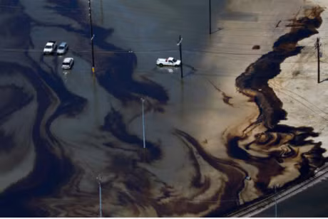 Những vệt dầu loang lổ giữa dòng lũ tại Texas. Ảnh: Reuters