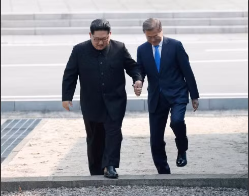 Hai nhà lãnh đạo cùng nắm tay bước qua ranh giới giữa hai nước vào sáng ngày 27-4. Ảnh: Reuters