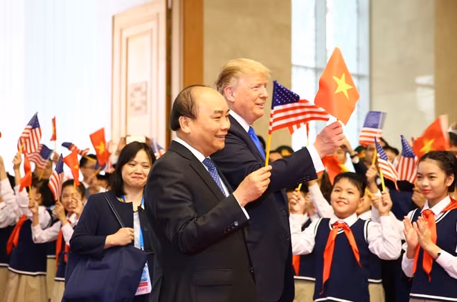 Hai nhà lãnh đạo cùng tươi cười vẫy lá cờ Việt - Mỹ trước đông đảo mọi người.