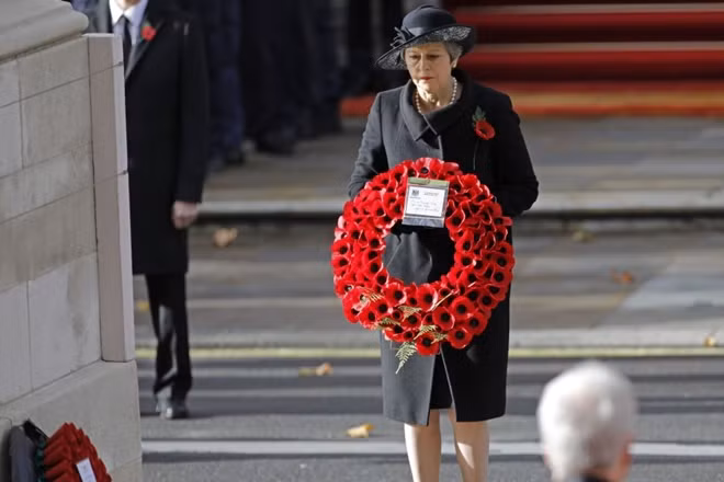Thủ tướng Anh Theresa May đặt vòng hoa tưởng nhớ những người lính đã hi sinh. Ảnh: The Guardian