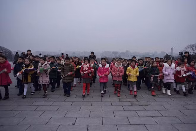 Đoàn trẻ em đến dâng hoa tại tượng đài cố lãnh đạo Triều Tiên Kim Il Sung và Kim Jong-il ở đồi Mansudae, Bình Nhưỡng ngày 16-2 để tỏ lòng kính trọng của các em nhân ngày sinh nhật lần thứ 75 của Chỉ tịch Kim Jong-il. Ảnh: AP