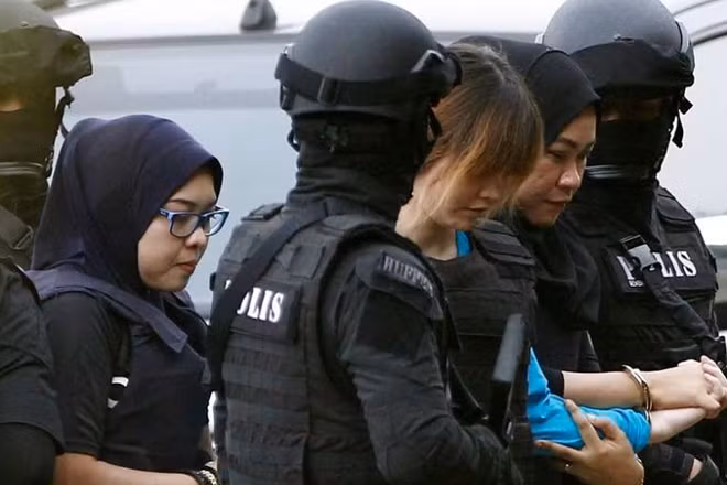 Nghi phạm được mặc áo chống đạn và có bảo vệ đi cùng. Ảnh: Reuters
