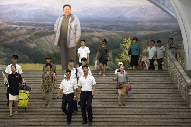 Bức tranh lớn về cố lãnh đạo Kim Jong-Il được đặt tại khu vực ga tàu điện trong trung tâm thủ đô Bình Nhưỡng. Bức ảnh được nhiếp ảnh gia chụp vào thời điểm người dân đang hối hả rảo bước để kịp chuyến tàu điện tới nơi làm việc.