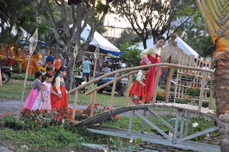 Những cô bé người Hàn Quốc thích thú đi cầu khỉ cùng mẹ.
