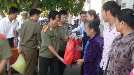 Trung tá Nguyễn Đức Vinh - đại diện Báo Công an nhân dân trao quà cho bà con.
