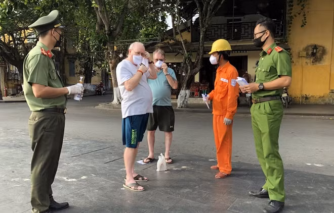 Tuổi trẻ Công an Quảng Nam cùng đoàn viên Thành đoàn Hội An phát khẩu trang cho du khách nước ngoài.
