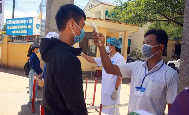 Học sinh tại tỉnh Quảng Ngãi được đo thân nhiệt trước khi vào đăng ký thi THPT chiều 8/8. Ảnh: C.T.V