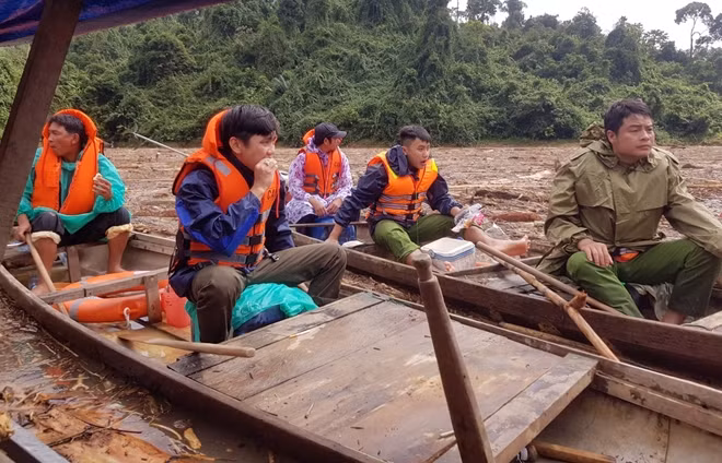 Cán bộ chiến sĩ Công an tranh thủ ăn bánh mì trên ghe để dành thời gian tiếp tục tìm kiếm nạn nhân.