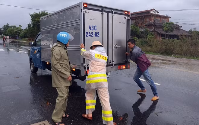CSGT giúp đỡ phương tiện bị "chết" máy trên QL1A đoạn bị ngập lụt.