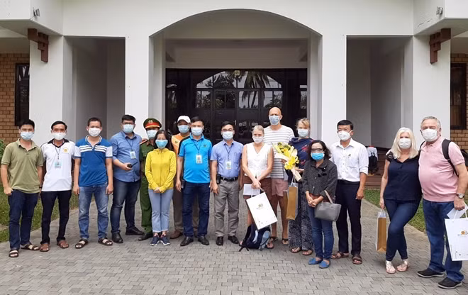 5 du khách người Anh chụp hình lưu niệm với cán bộ chiến sĩ trước khi rời khu lưu trú an toàn Hội An Beach Resort.