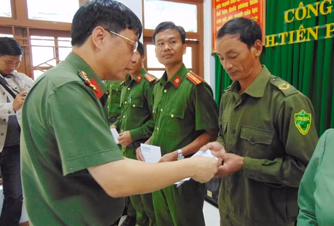 Đại tá Phạm Khải, Tổng Biên tập Báo CAND trao quà cho CBCS Công an huyện Tiên Phước nỗ lực tham gia tuyến đầu giúp đỡ người dân trong bão lũ.