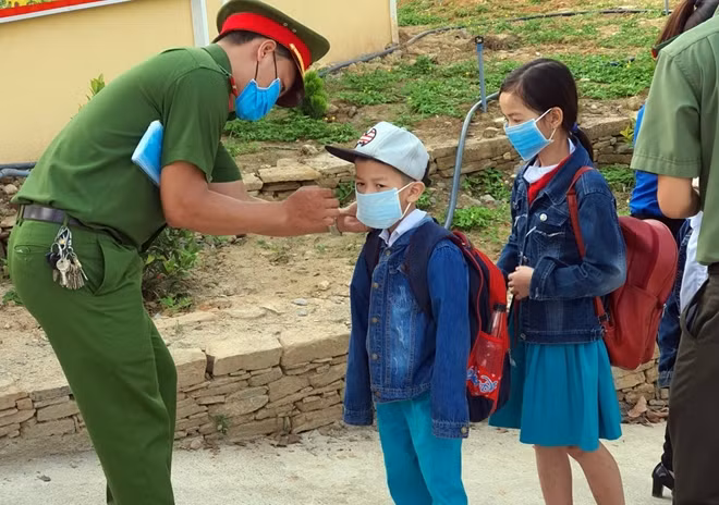 Đeo khẩu trang y tế mới cho các em học sinh trước khi vào lớp.