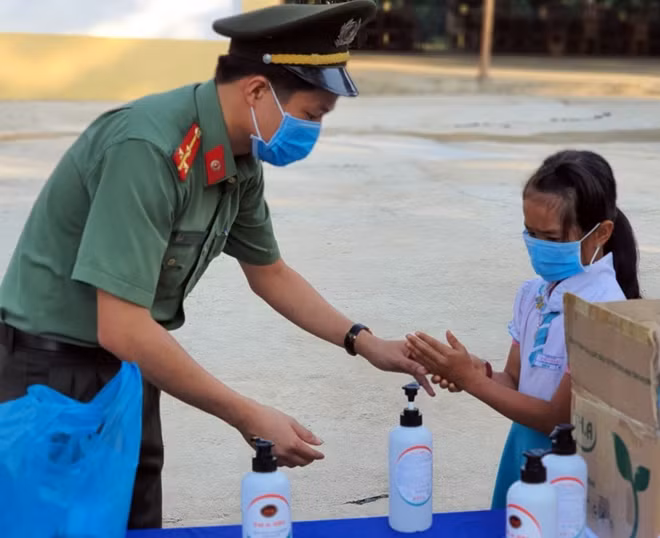 Hướng dẫn các em học sinh rửa tay sát khuẩn.