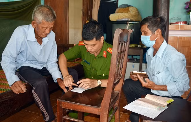 Cán bộ Phòng Cảnh sát QLHC về TTXH Công an tỉnh Quảng Nam đến tận nhà làm CMND cho cụ ông Lê Thanh Bảy (90 tuổi, trú xã Tam Thanh, TP Tam Kỳ).