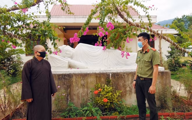 Cán bộ Công an huyện Đông Giang trao đổi với Đại đức Thích Hiện Thể về công tác phòng chống COVID-19 tại chùa Đông An.