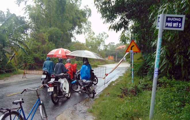 Lực lượng chức năng lập rào chắn trên tuyến ĐT609B phía từ xã Đại Hiệp vào thị trấn Ái Nghĩa, huyện Đại Lộc do nước lũ dâng cao, ngập sâu.