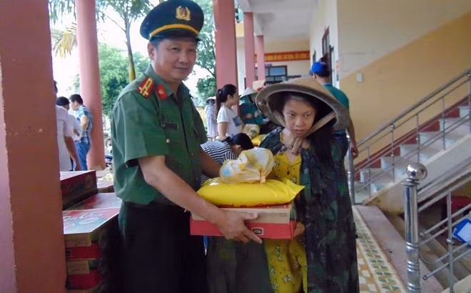 Thượng tá Nguyễn Văn Long, Phó Trưởng Ban Thư ký Tòa soạn, Trưởng Văn phòng Thường trú miền Trung Báo CAND, trao quà cho người dân xã Đại Hưng, huyện Đại Lộc.