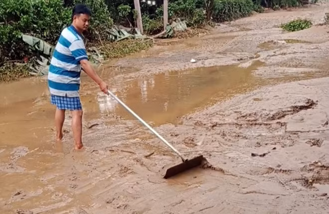 Người dân xã Đại Hưng, huyện Đại Lộc dọn dẹp bùn đất sau khi lũ rút.