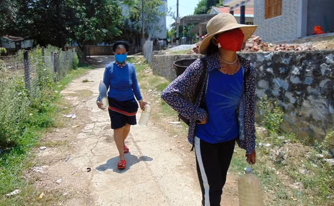 Người dân xã Cà Dy "đội nắng" đi gùi nước về dùng cho sinh hoạt.