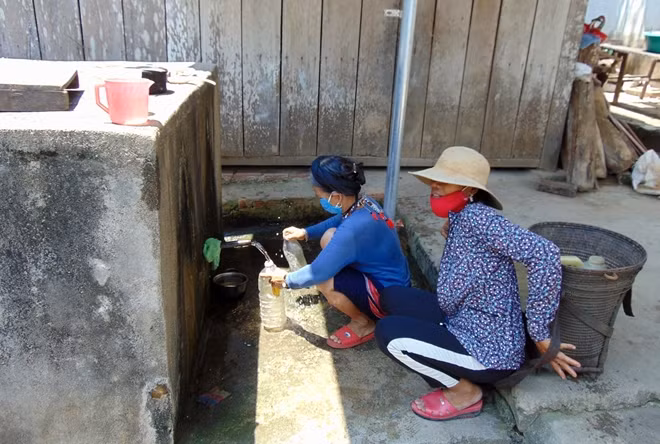Người dân thôn Pà Ôn, xã Cà Dy đến hộ gia đình có bể nước tự chảy còn hoạt động lấy nước về dùng.