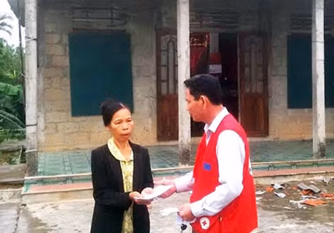 Đại diện hội Chữ thập đỏ huyện Phong Điền trao tiền hỗ trợ 500.000 đồng cho hộ bà Hoàng Thị Huê, ở thôn Sơn Tùng có nhà bị tốc mái.