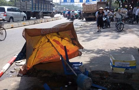 Chiếc xe ben lao qua phần đường dành cho xe hai bánh và tông vào một quán nước hạ gục bảng đường.